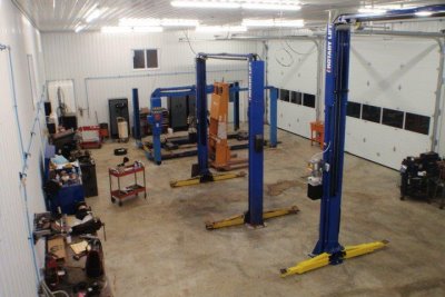 Inside the RT Automotive shop showing multiple service bays with blue vehicle lifts and diagnostic equipment